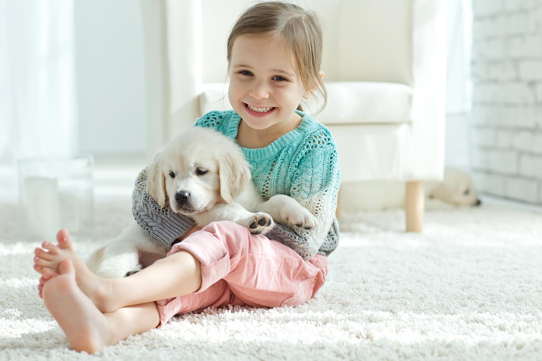 happy child on carpet with puppy